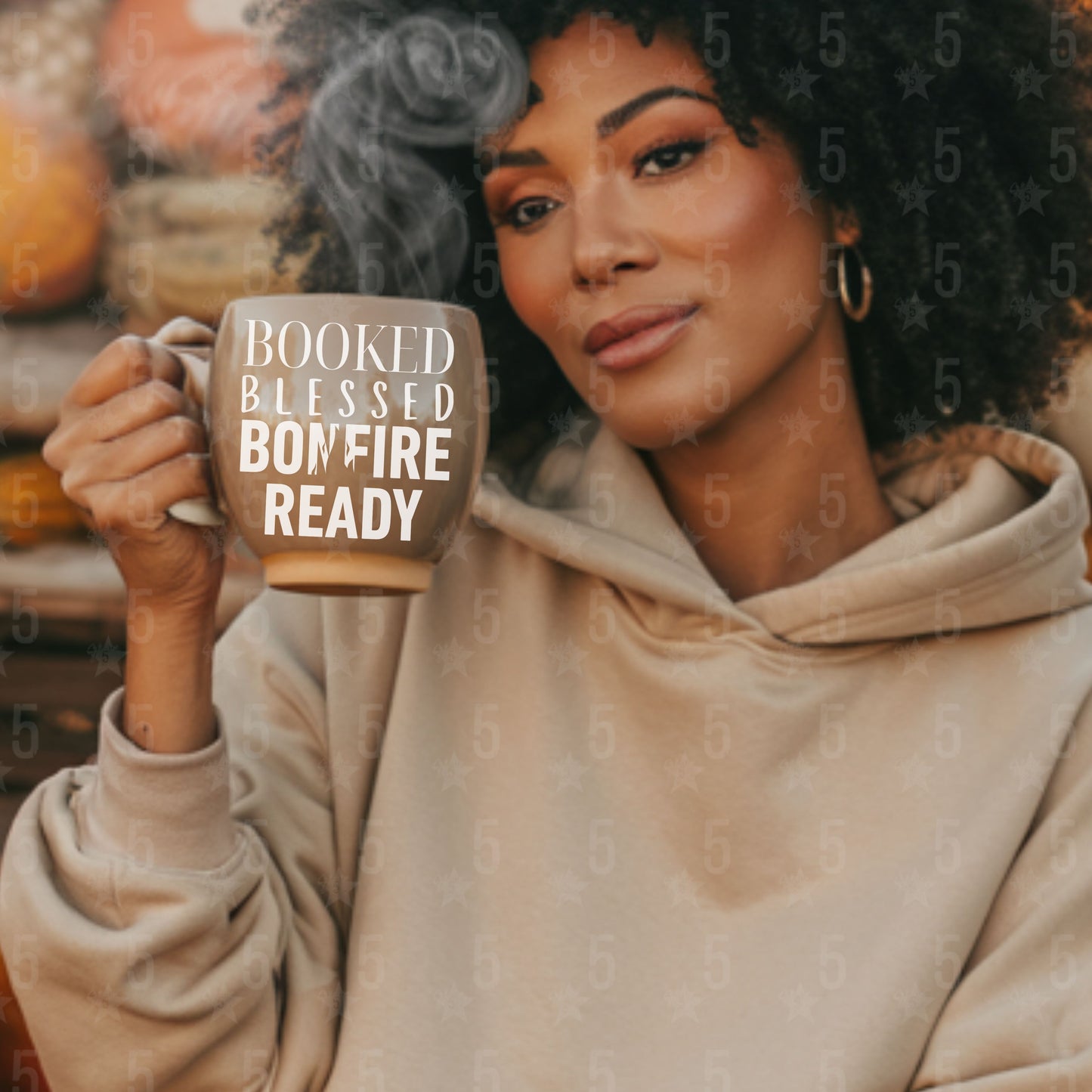 Woman holding a mug with 'Booked Blessed Bonfire Ready' text, surrounded by autumn decorations.