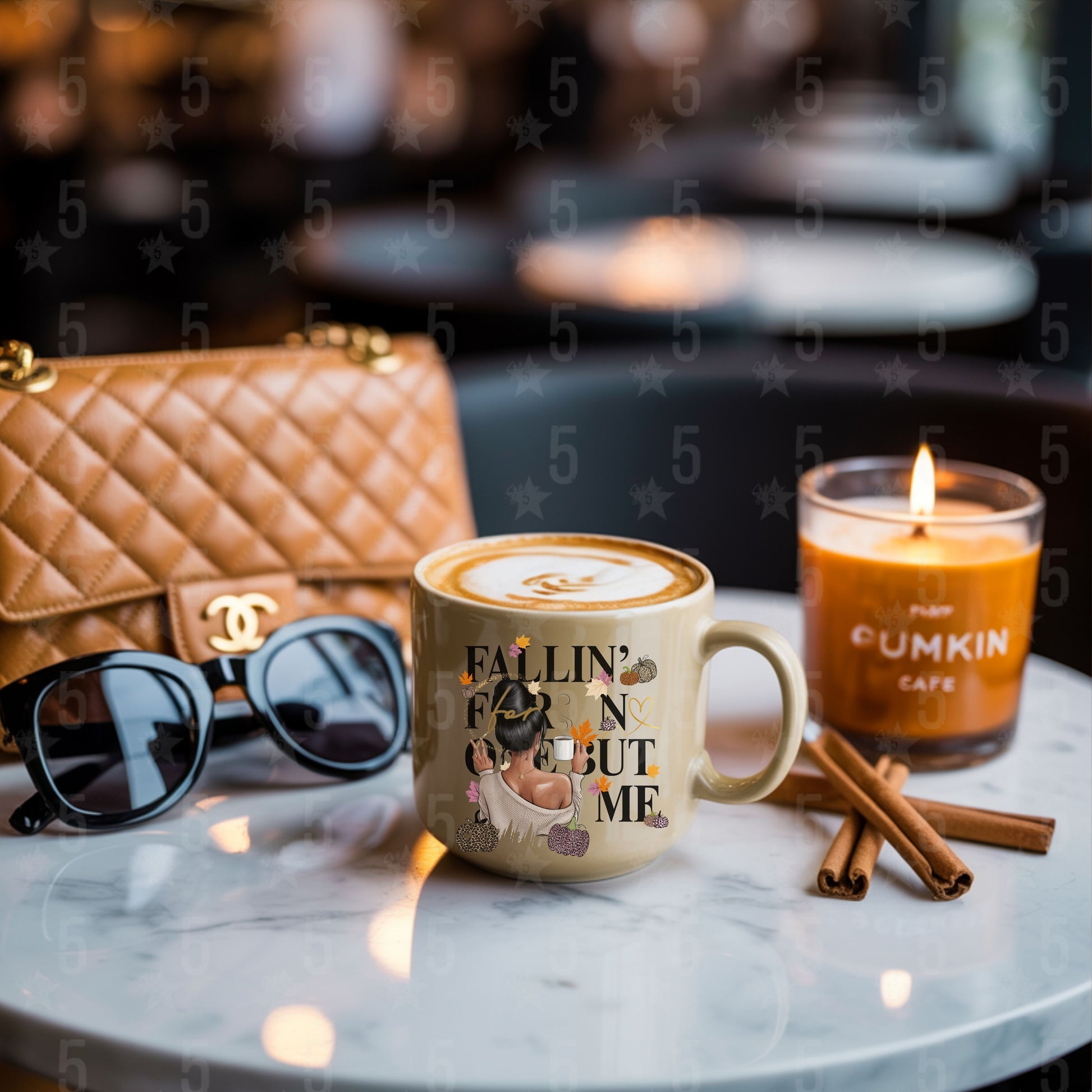 Café setting with a mug, candle, sunglasses, and cinnamon sticks on a marble surface.