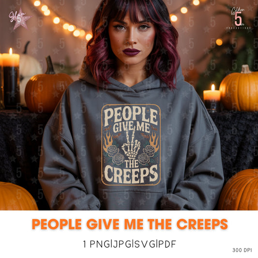Person wearing a hoodie with 'People Give Me the Creeps' text in a Halloween-themed setting