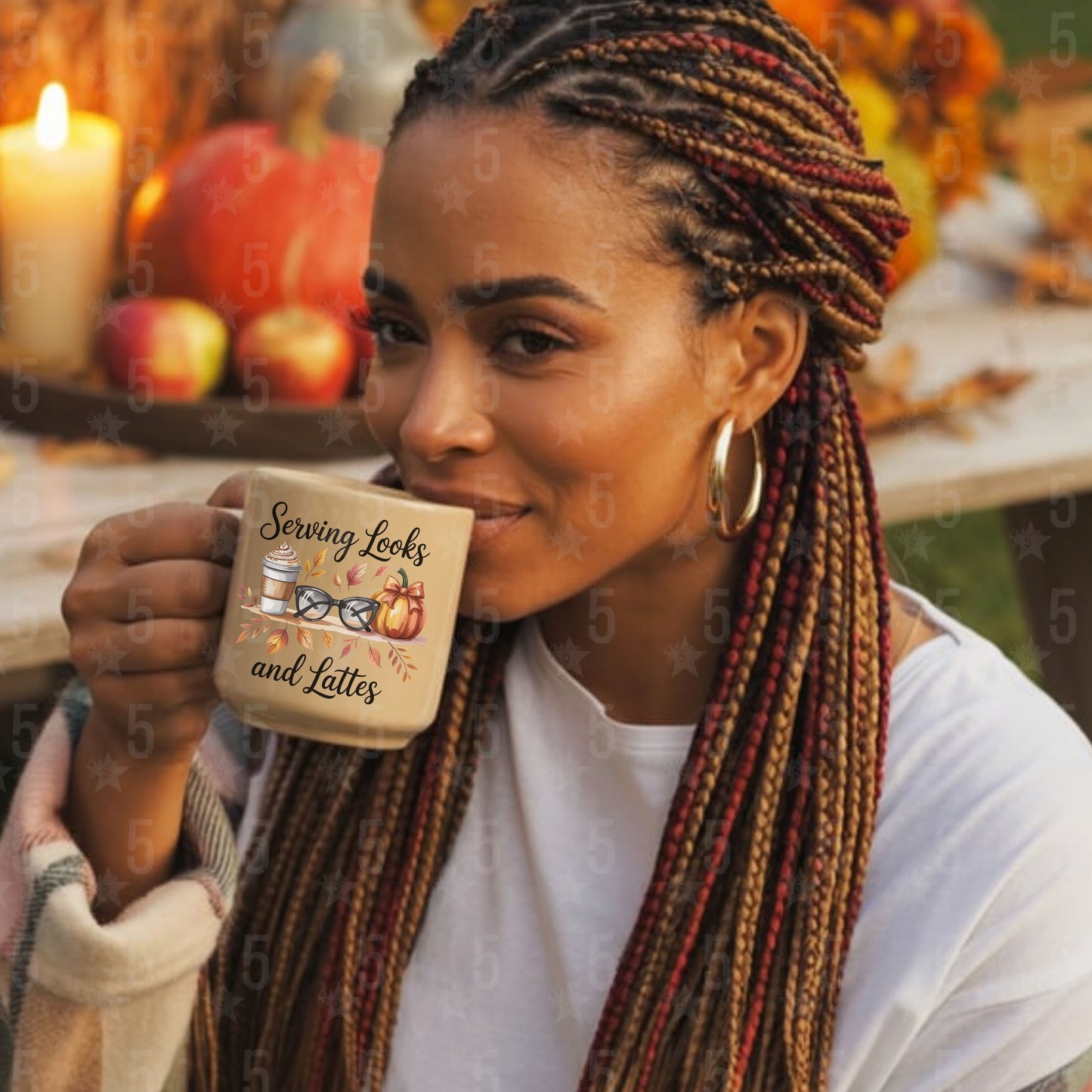 Woman holding a mug with a fall-themed design, surrounded by pumpkins and apples.