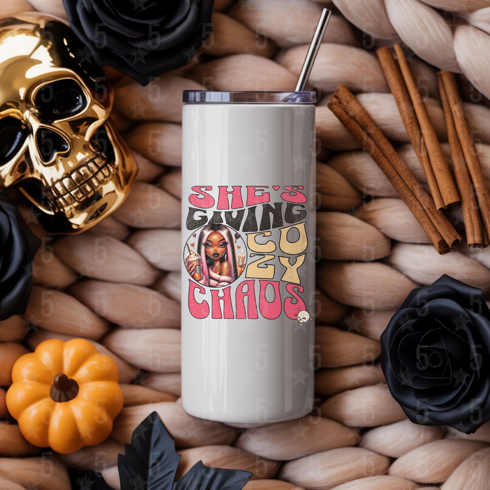 Tumbler with graphic design on a textured surface with decorative items