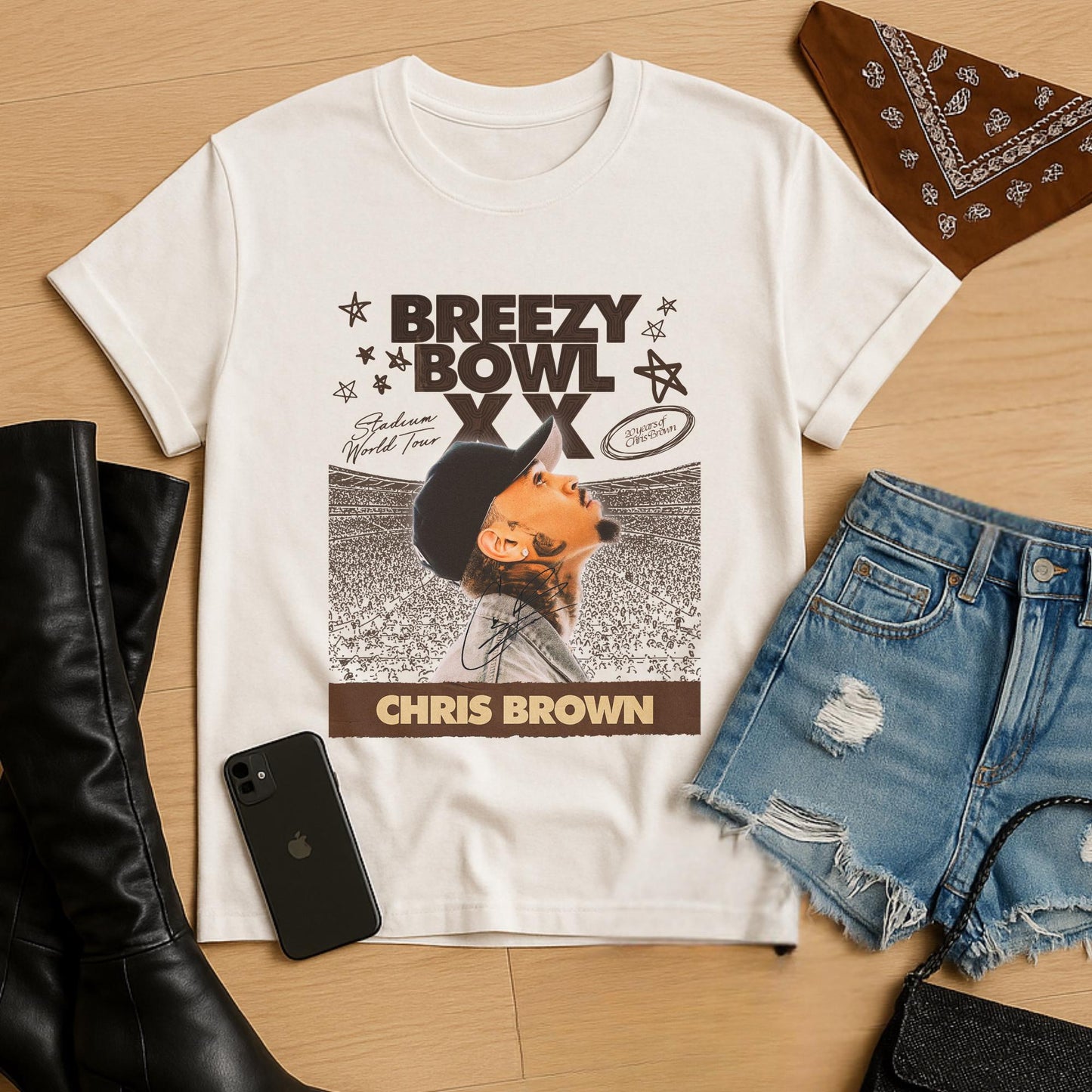White t-shirt with Chris Brown graphic design on a wooden surface with accessories.