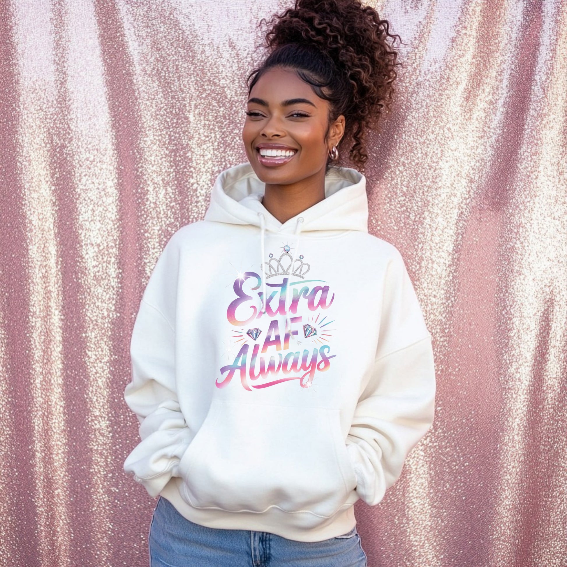 Woman wearing a white hoodie with colorful text against a pink glittery background