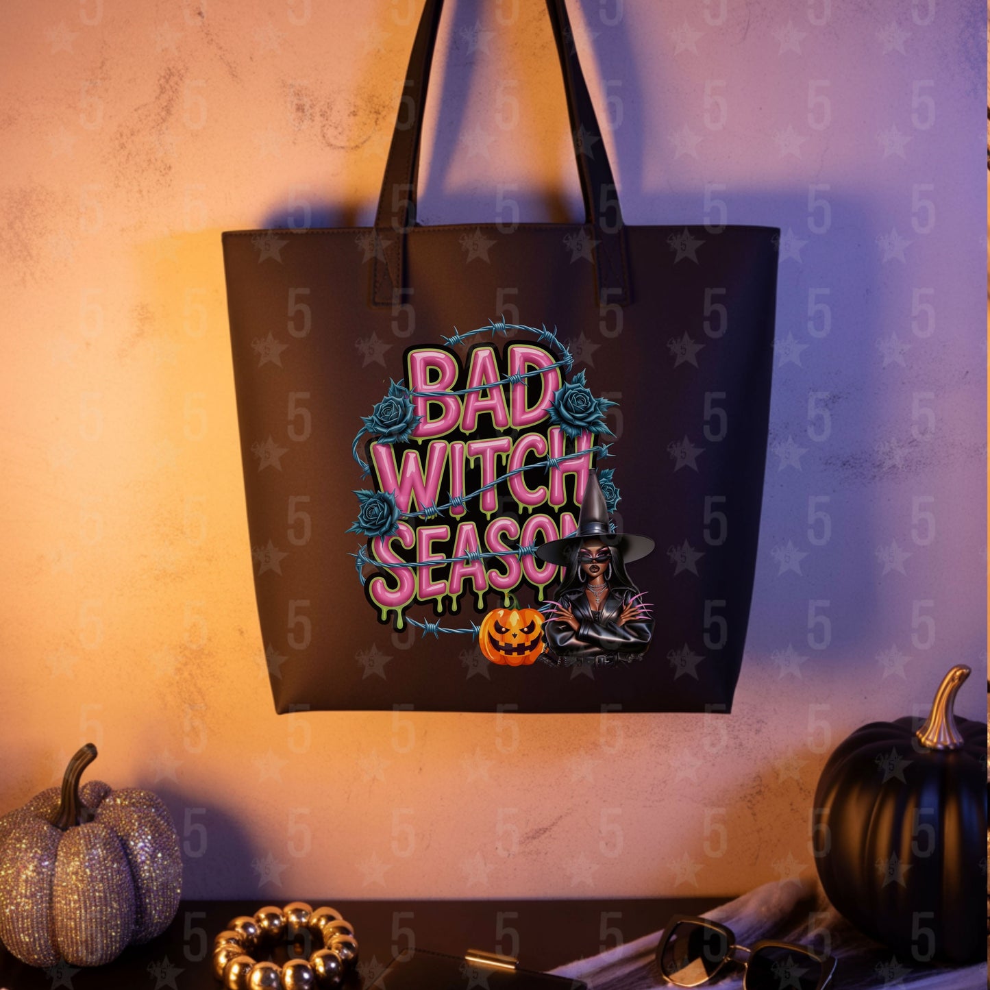 Tote bag with 'Bad Witch Season' design on a textured wall with pumpkins.