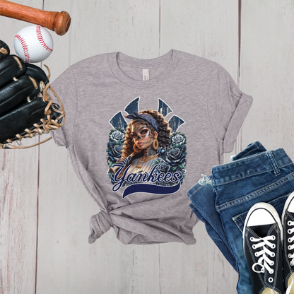 Gray t-shirt with dia de los muertos 'Yankees' design, baseball, bat, glove, and jeans on a wooden surface