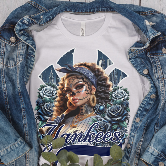 White t-shirt with dia de los muertos 'Yankees' design featuring a woman with tattoos and flowers, displayed with a denim jacket.