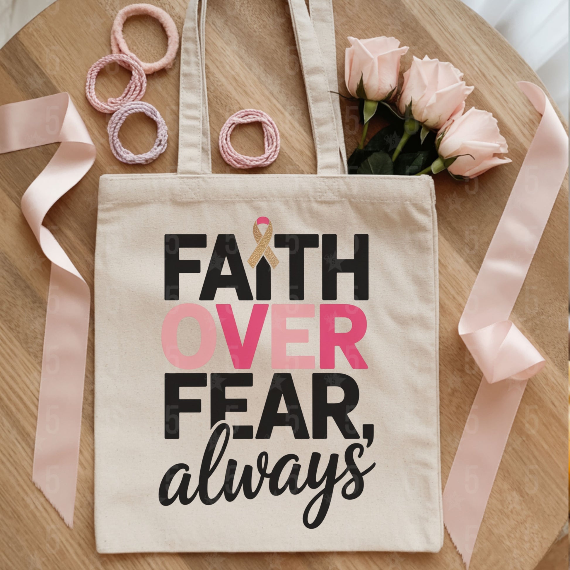 Tote bag with 'Faith Over Fear, always' text on a wooden surface with ribbons and flowers.