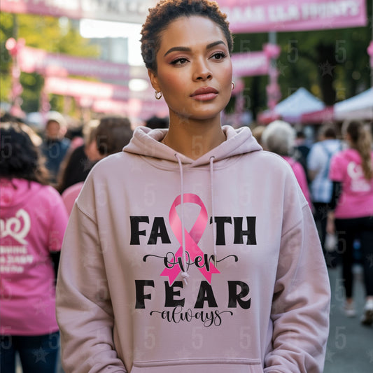 Woman wearing a pink hoodie with a breast cancer awareness message at an event.