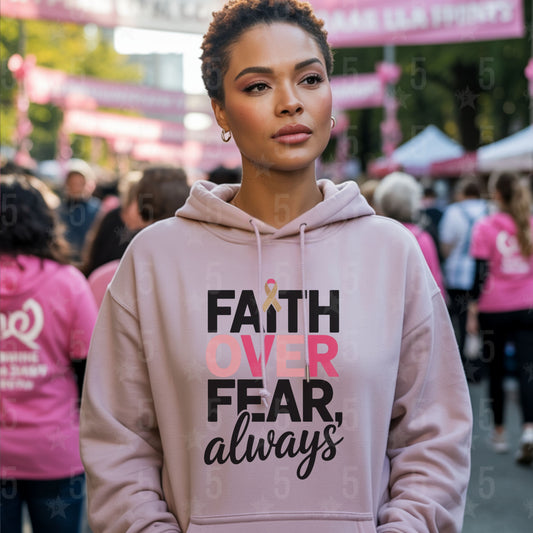 Woman wearing a pink hoodie with 'Faith Over Fear, always' text in a crowded outdoor setting.