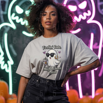 Person wearing a t-shirt with a ghost graphic and text in front of Halloween-themed decorations.