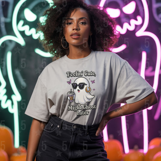 Person wearing a t-shirt with a ghost graphic and text in front of Halloween-themed decorations.