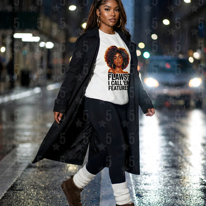 Woman walking on a city street at night wearing a long coat and a t-shirt with a graphic design.