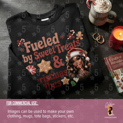 Black t-shirt with festive design featuring text and graphics, placed on a dark surface with a mug and candle.