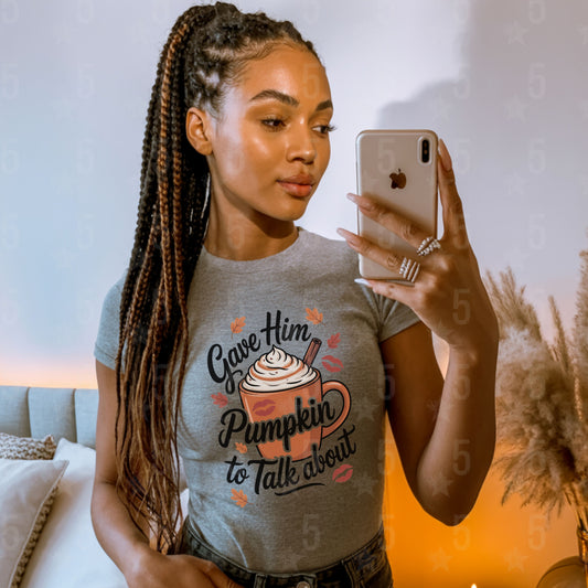 Woman taking a mirror selfie wearing a t-shirt with a pumpkin spice latte design.