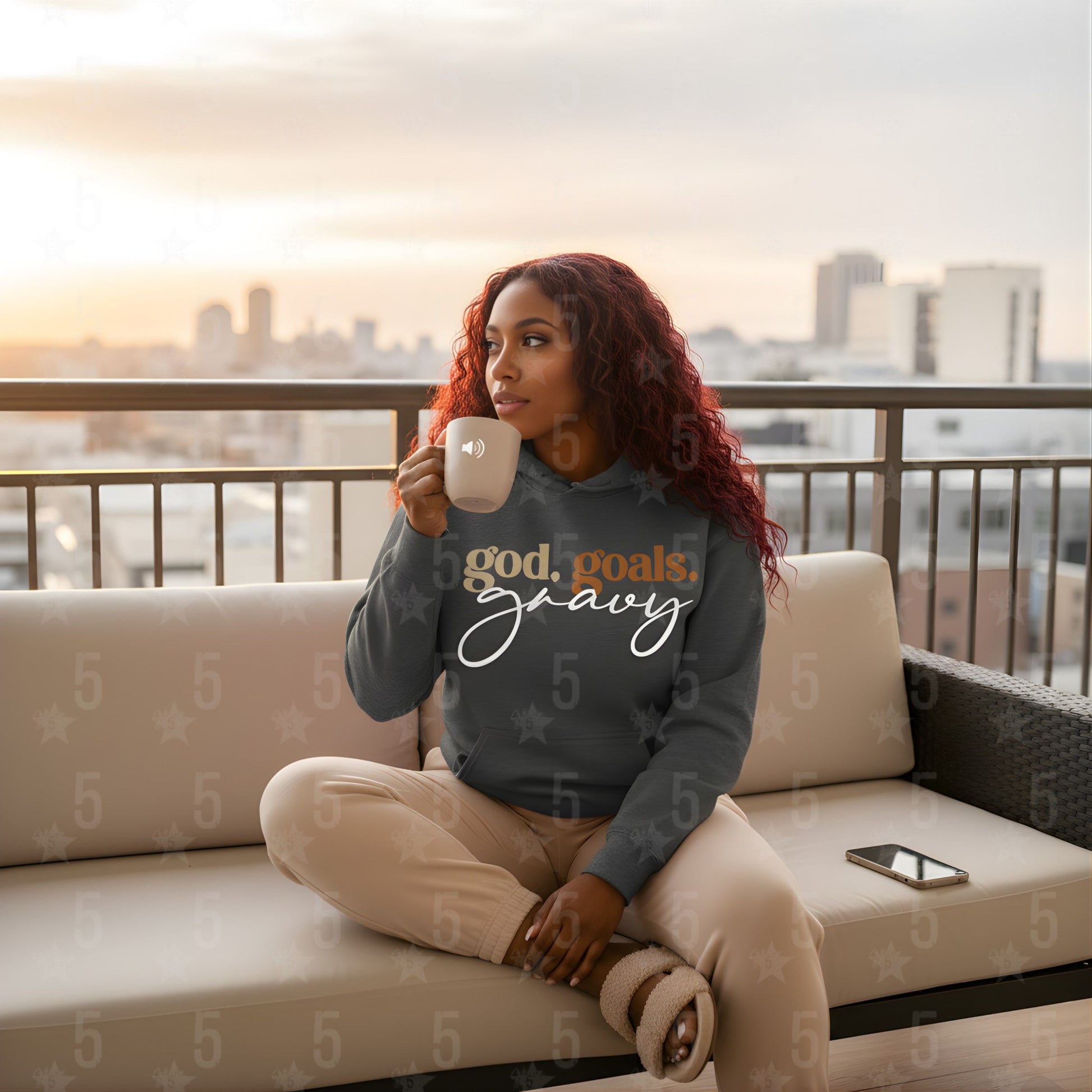 Woman sitting on a couch holding a mug with a cityscape in the background