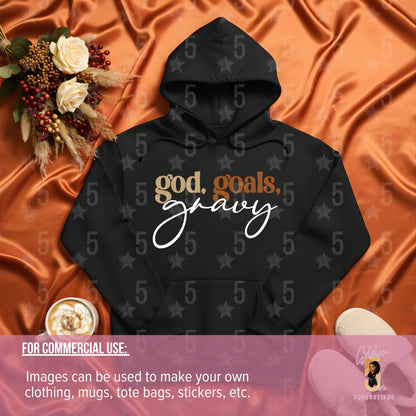 Black hoodie with 'god, goals, gravy' text on an orange fabric background with flowers and a cup.