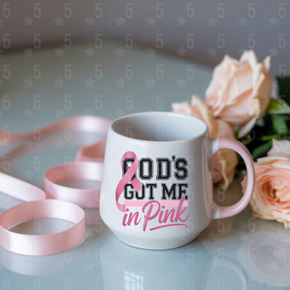 White mug with 'God's got me in pink' text and pink roses on a light background