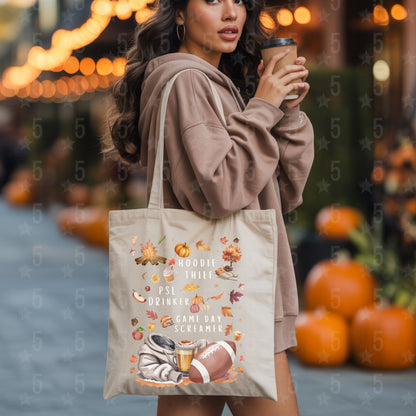 Woman holding a coffee cup and a tote bag with autumn-themed design in an outdoor setting with pumpkins.