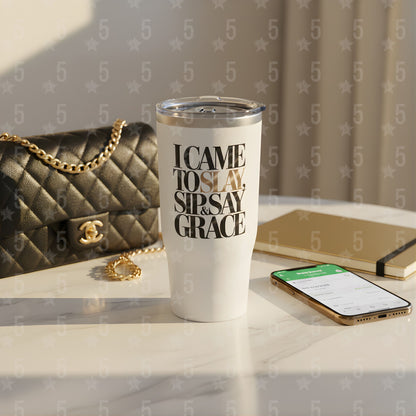 White tumbler with text on a surface with a handbag and phone in the background