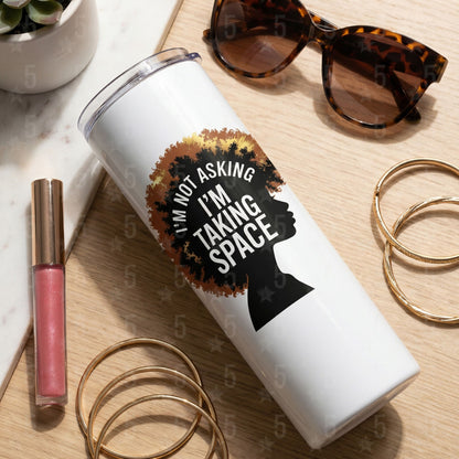 White tumbler with a motivational quote on a wooden surface with accessories.