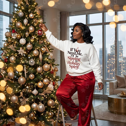 Woman decorating a Christmas tree in a room with large windows and cityscape view.