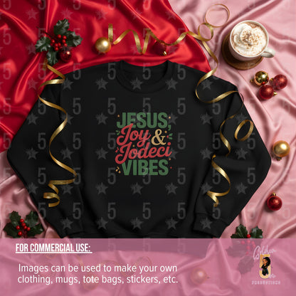 Black sweatshirt with colorful text on a pink and red fabric background with Christmas decorations.