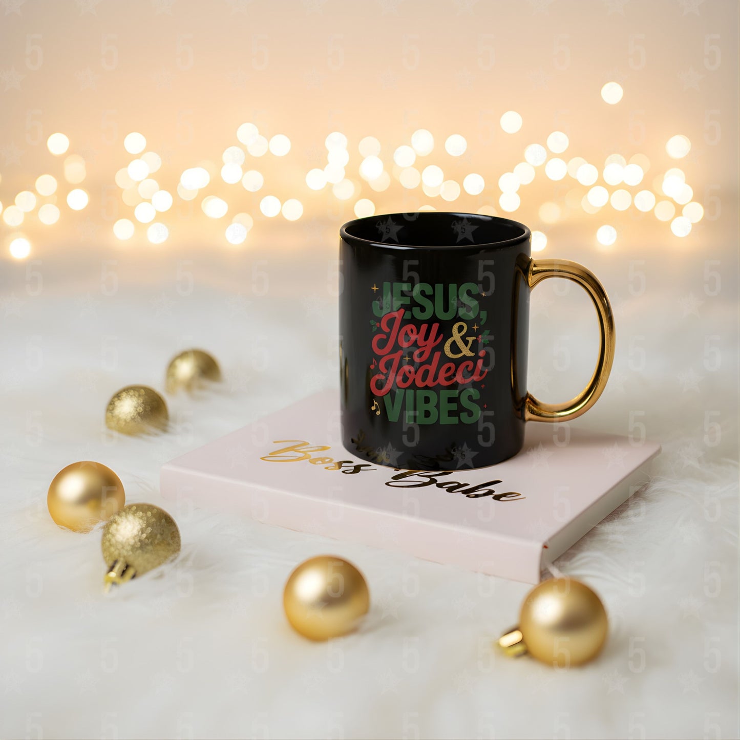 Black mug with colorful text on a book with gold ornaments and blurred lights in the background