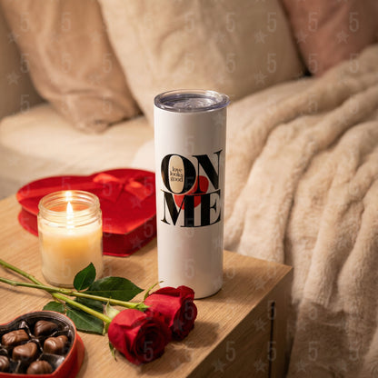 Tumbler with 'ON ME' text, candles, roses, and chocolates on a wooden surface.