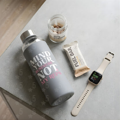 A water bottle, smartwatch and protein bar on a table