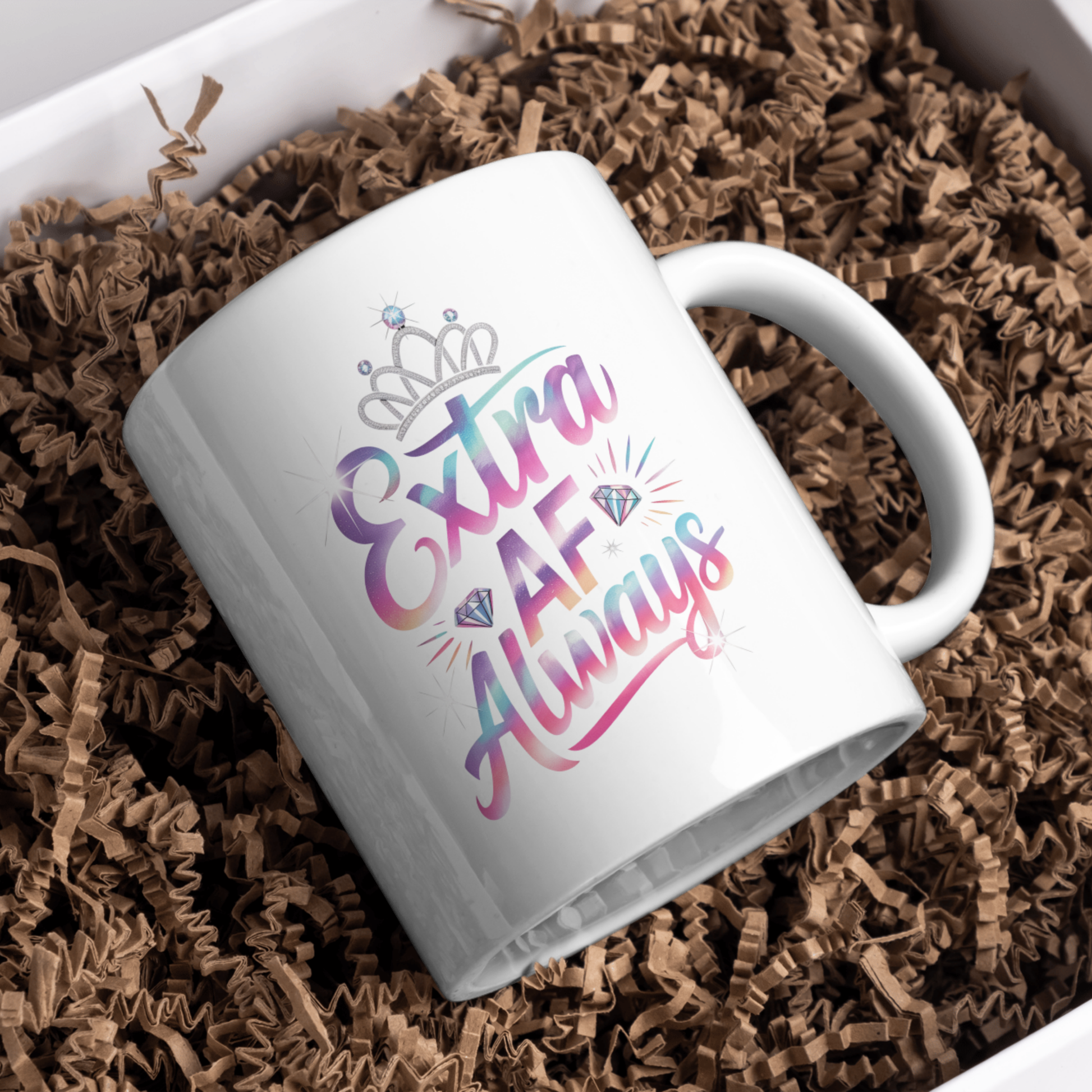 White mug with colorful text on a bed of brown paper shreds