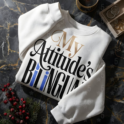 White sweatshirt with text 'My Attitude's Bilingual' on a dark marble surface.