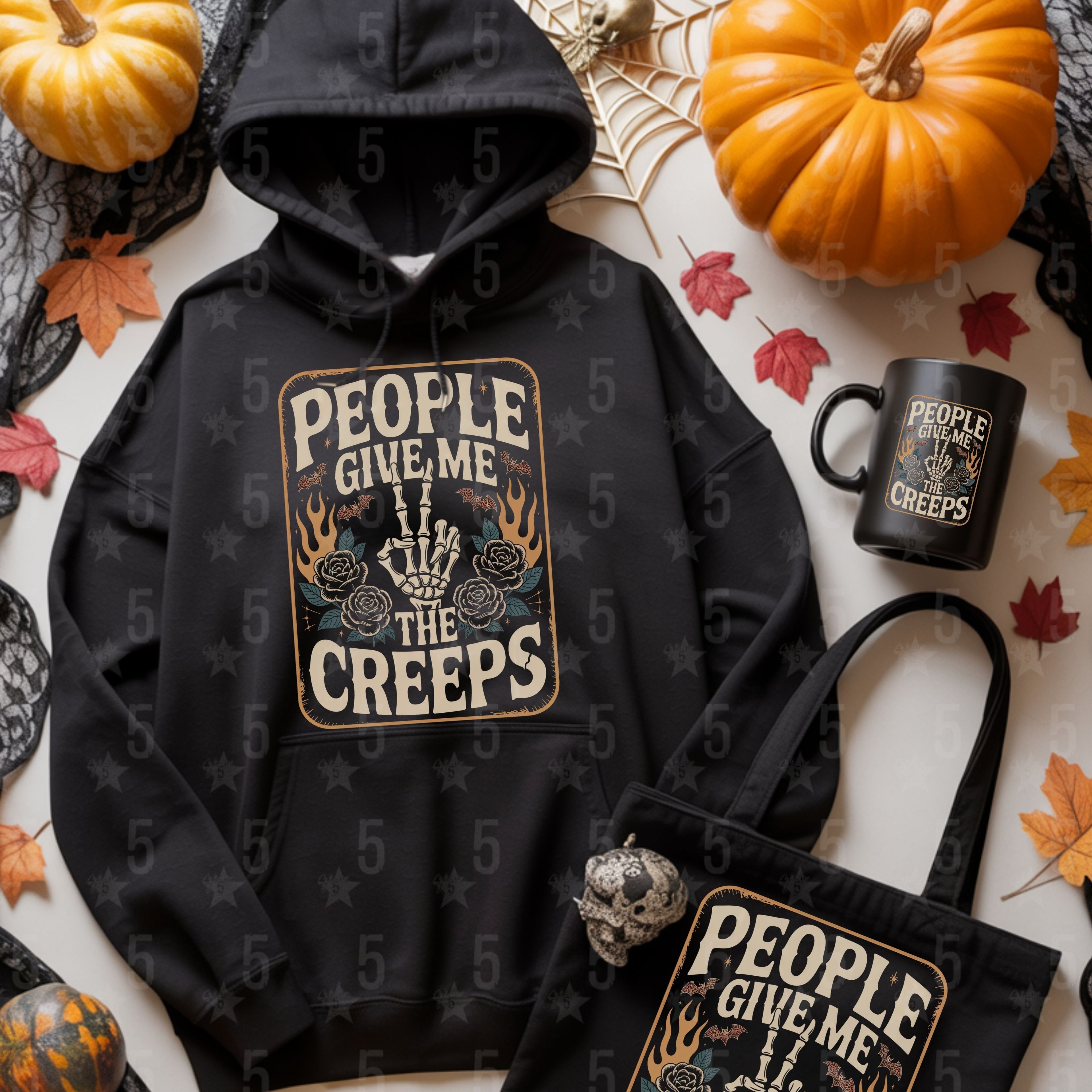 Black hoodie, mug, and tote bag with Halloween-themed design on a white background with pumpkins and leaves.