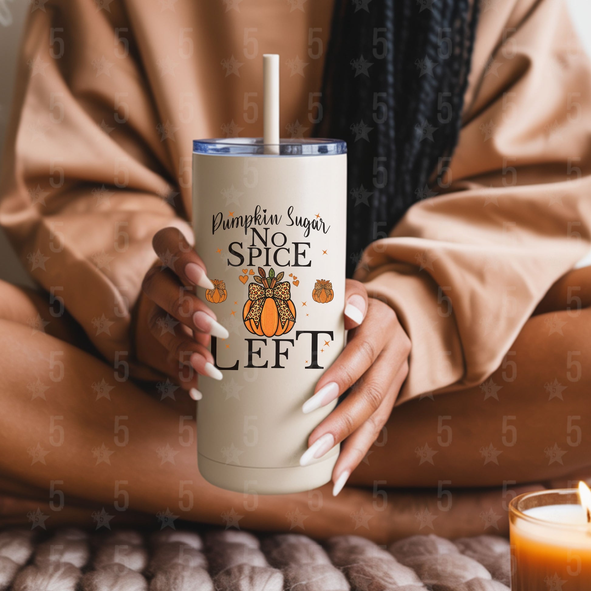 Person holding a beige tumbler with pumpkin spice design and text.