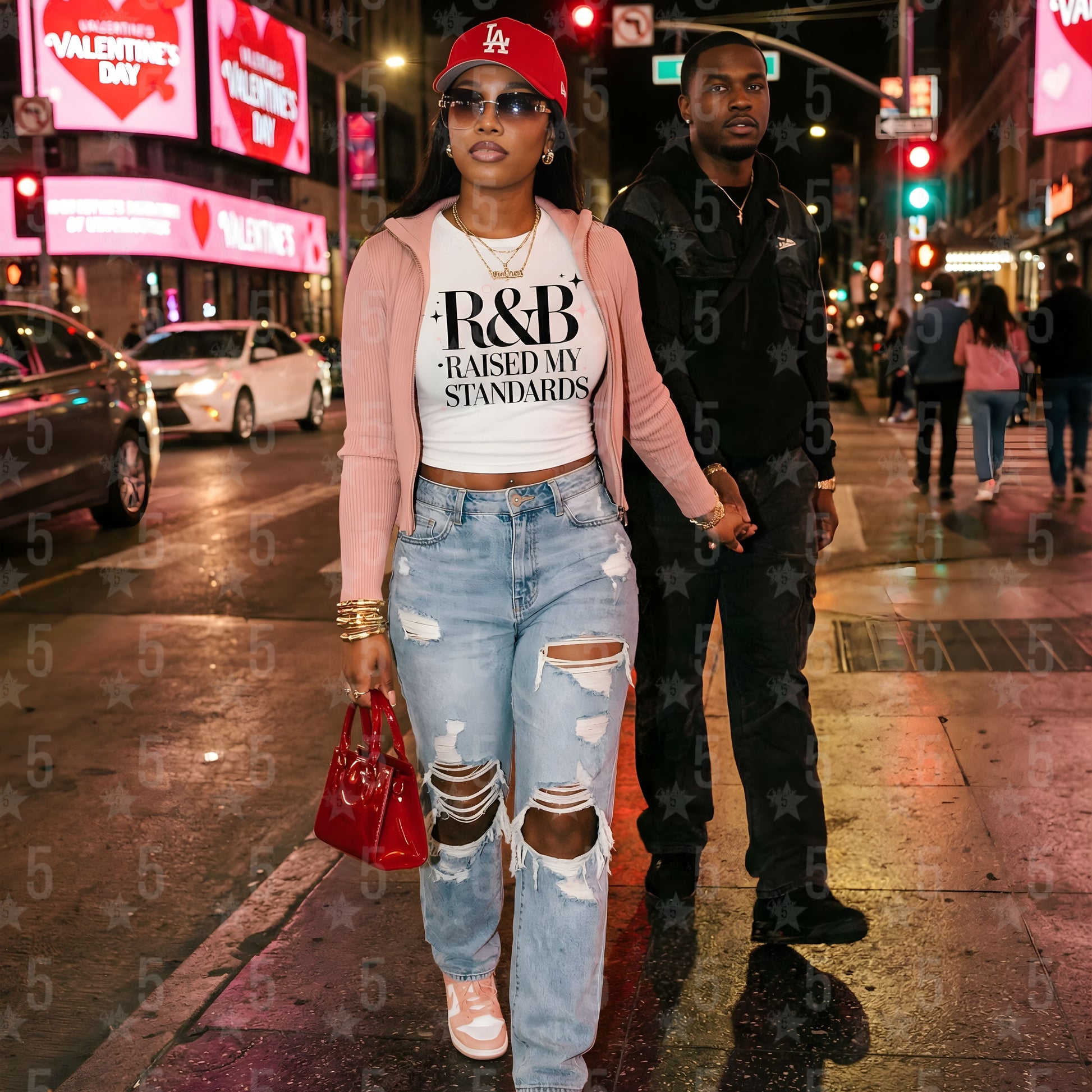 A couple walking on a city street at night with Valentine's Day decorations.