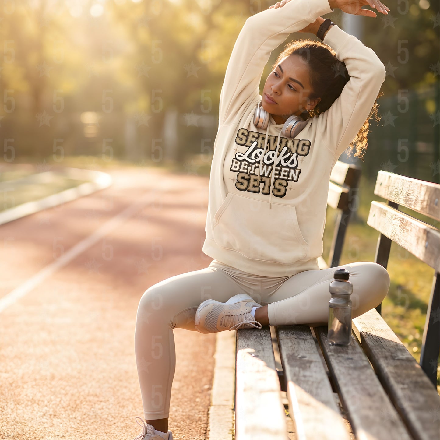 a woman stretching on a park bench in a beige fitness hoodie