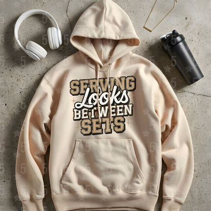 a beige hoodie laid flat on the ground with headphones. and a protein bottle shaker