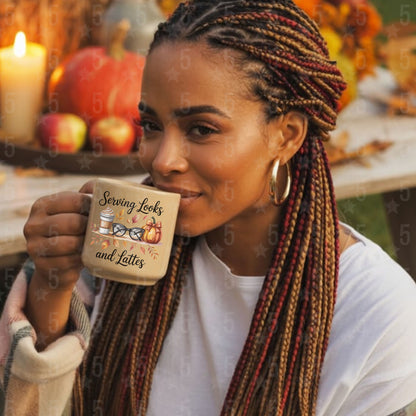 Woman holding a mug with a fall-themed design, surrounded by pumpkins and apples.