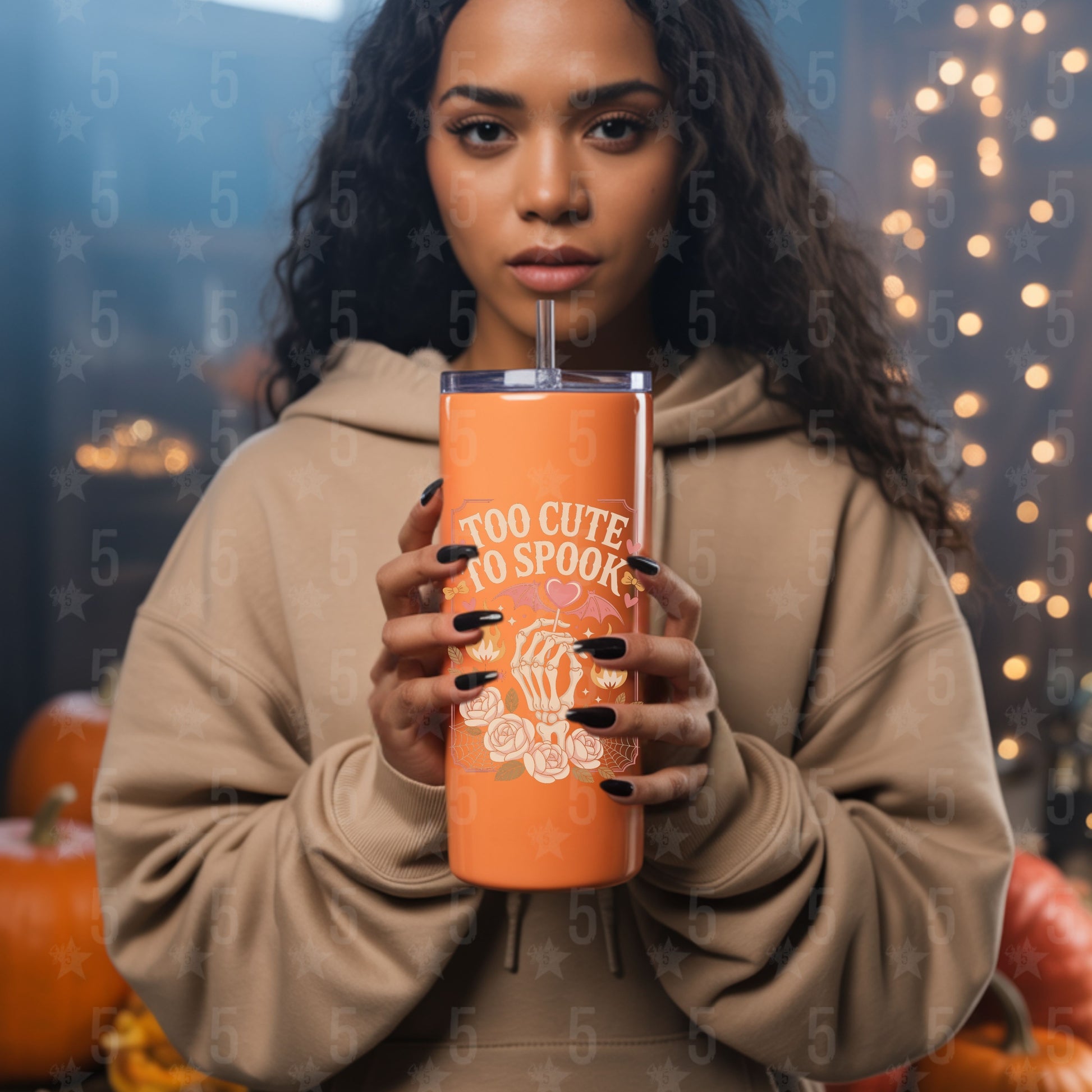 Woman holding an orange tumbler with Halloween design against a festive background