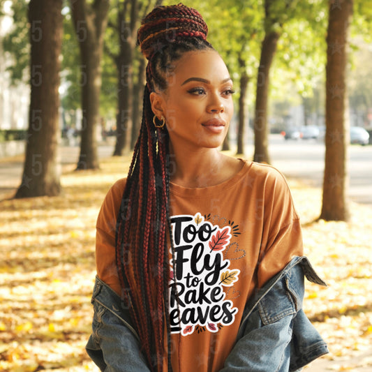 Woman wearing a brown shirt with text and graphics in an outdoor setting with trees and fallen leaves.