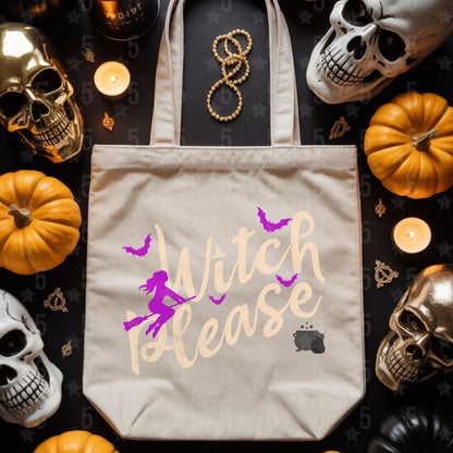 Beige tote bag with 'Witch Please' design surrounded by Halloween decorations on a dark surface.