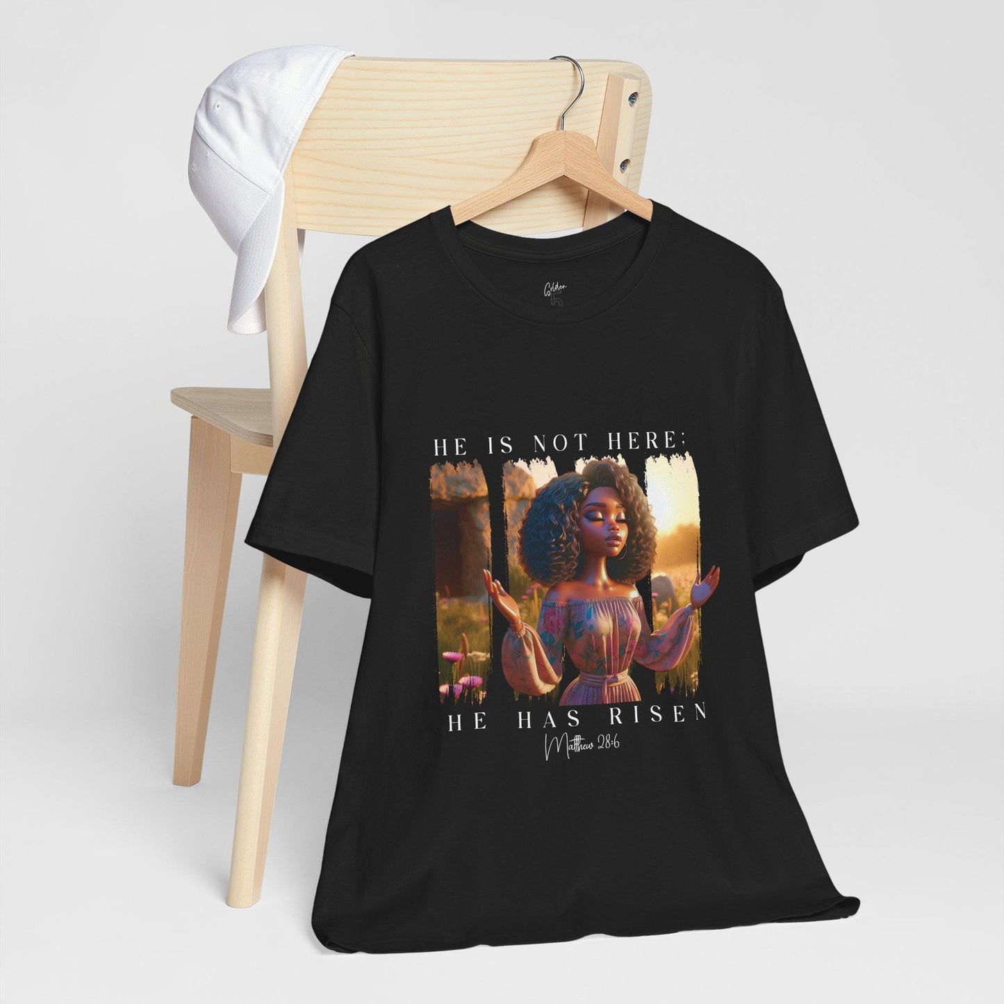 Black t-shirt hanging with a 'He Is Not Here' graphic on a white background