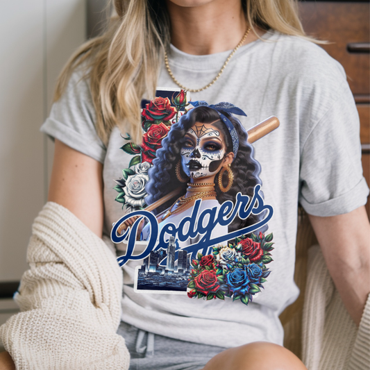 Person wearing a t-shirt with a graphic dia de los muertos design featuring 'Dodgers' and floral elements.