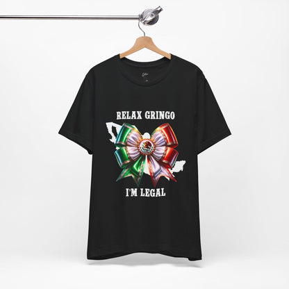 Black t-shirt with a Mexico bow graphic and text 'Relax Gringo I'm Legal' on a hanger against a white background