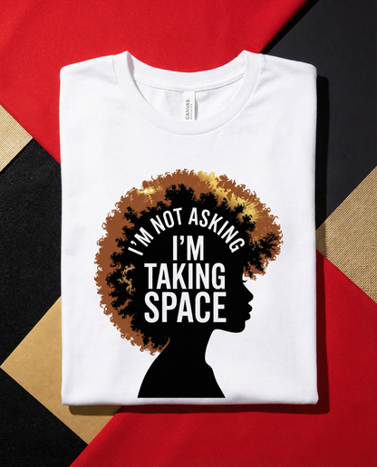 White t-shirt with a graphic of a silhouette with an afro and text 'I'm not asking, I'm taking space' on a red and black background.