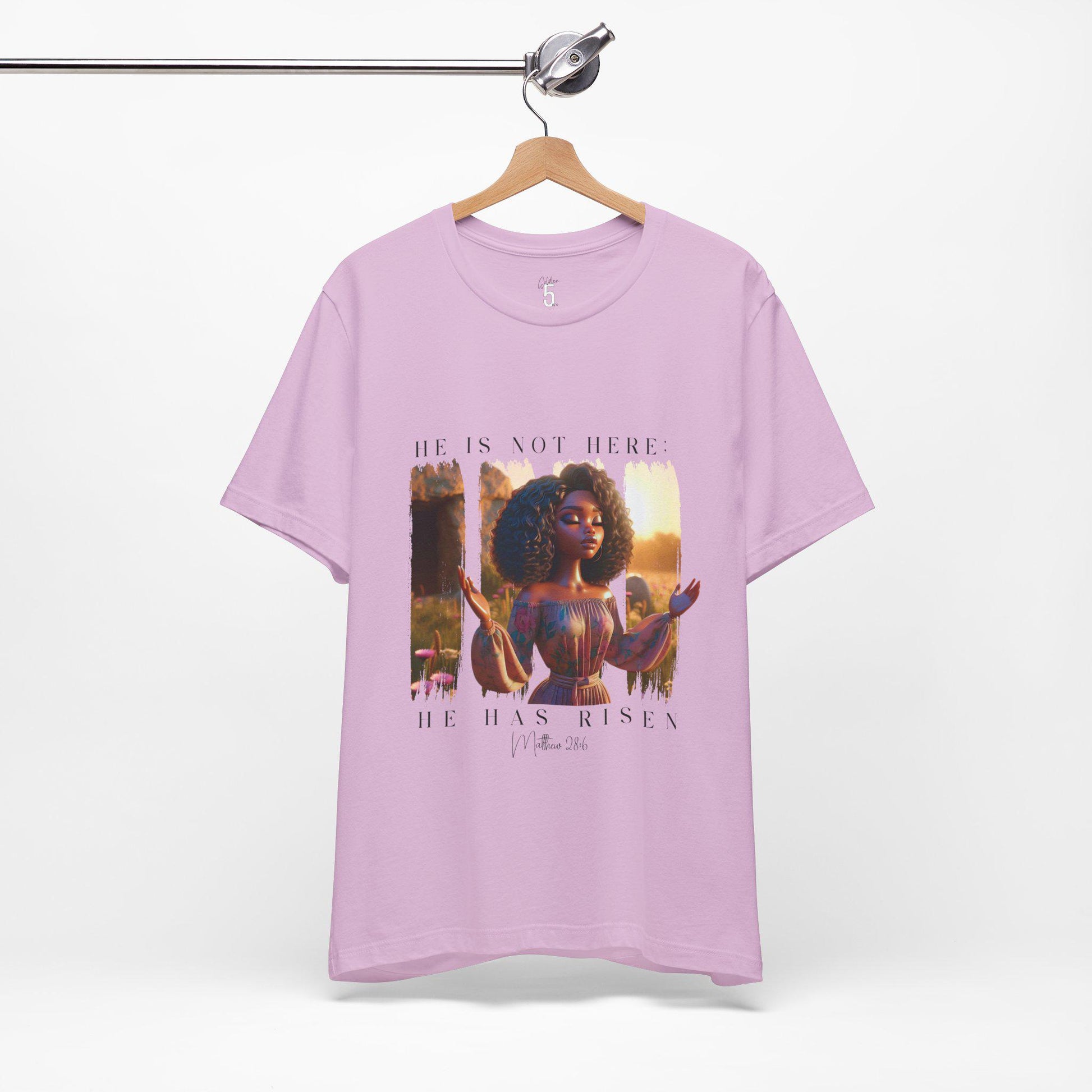 Lavender t-shirt with a 'He is Not Here' design on a hanger against a white background