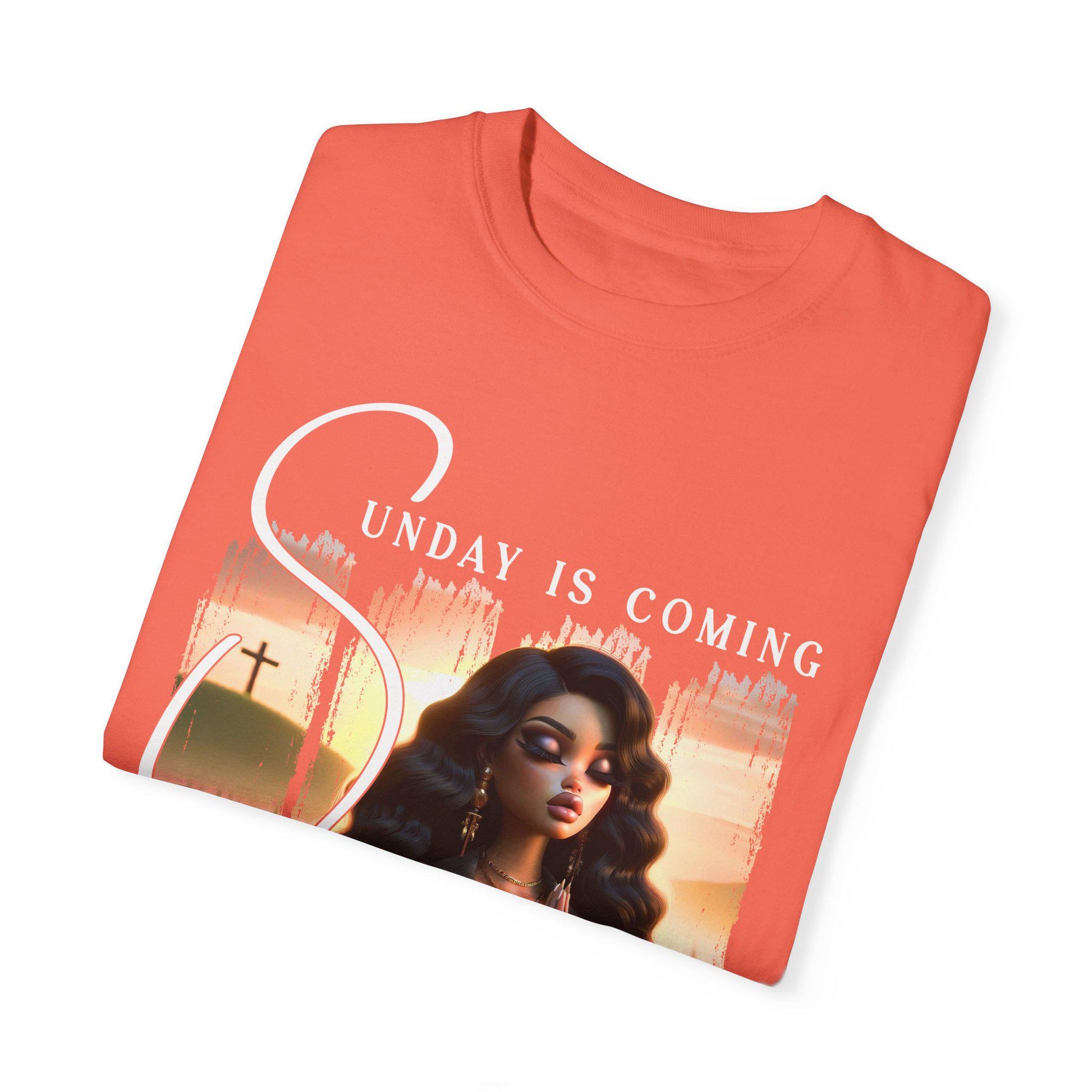 Folded coral t-shirt with a sunday is coming design on a white background
