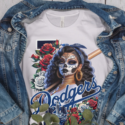 White t-shirt with Dodgers logo and graphic design of a woman with face paint and roses, displayed with a denim jacket.