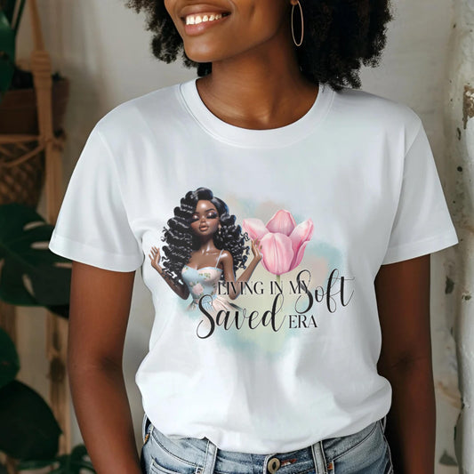 Person wearing a white t-shirt with a graphic of a woman holding a pink flower and text.